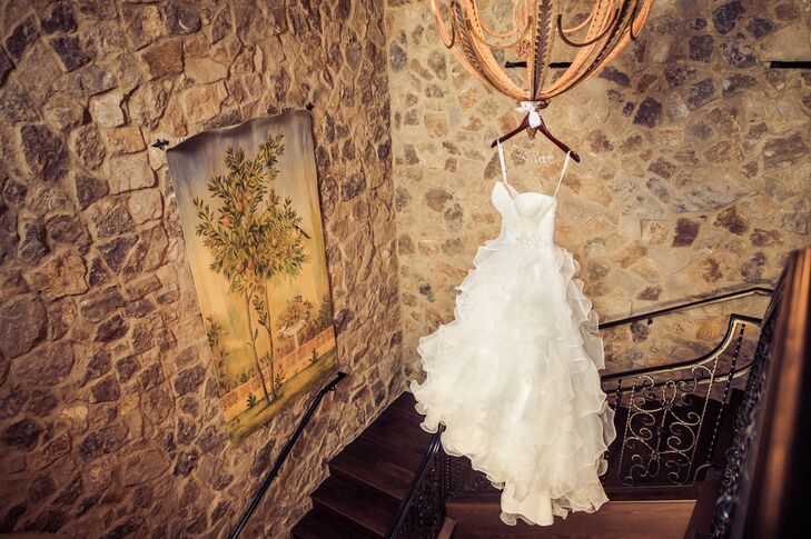 Lora chose and ivory Allure ball gown, style 8955, with romantic ruffle detailing for her wedding. It was accented with lace  on the bodice and an added Swarovski sash.