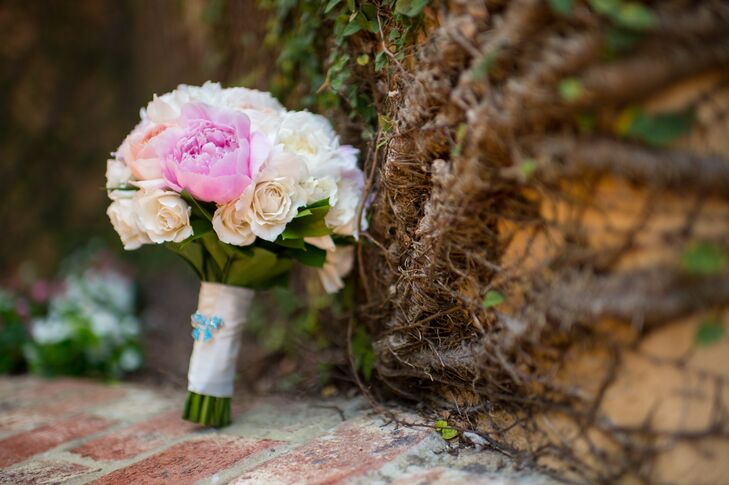 Lora chose peach and white rose bouquet accented with pink and white peonies. It was wrapped with ivory ribbon and a small blue ribbon pin.