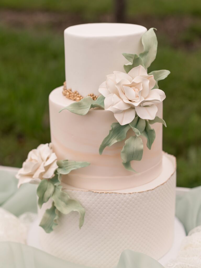 elegant ivory and blush fondant wedding cake with blush sugar flowers and greenery leaves