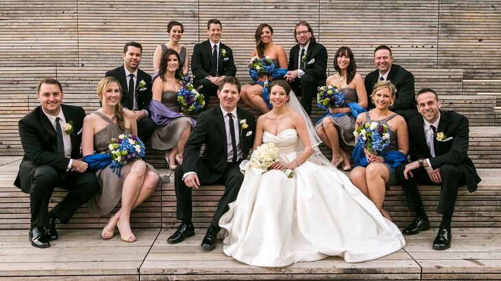 Terence and his groomsmen dressed in black suits and black ties, and they pinned white flower boutonnieres to their lapels. Their look complemented the gray bridesmaid dresses.