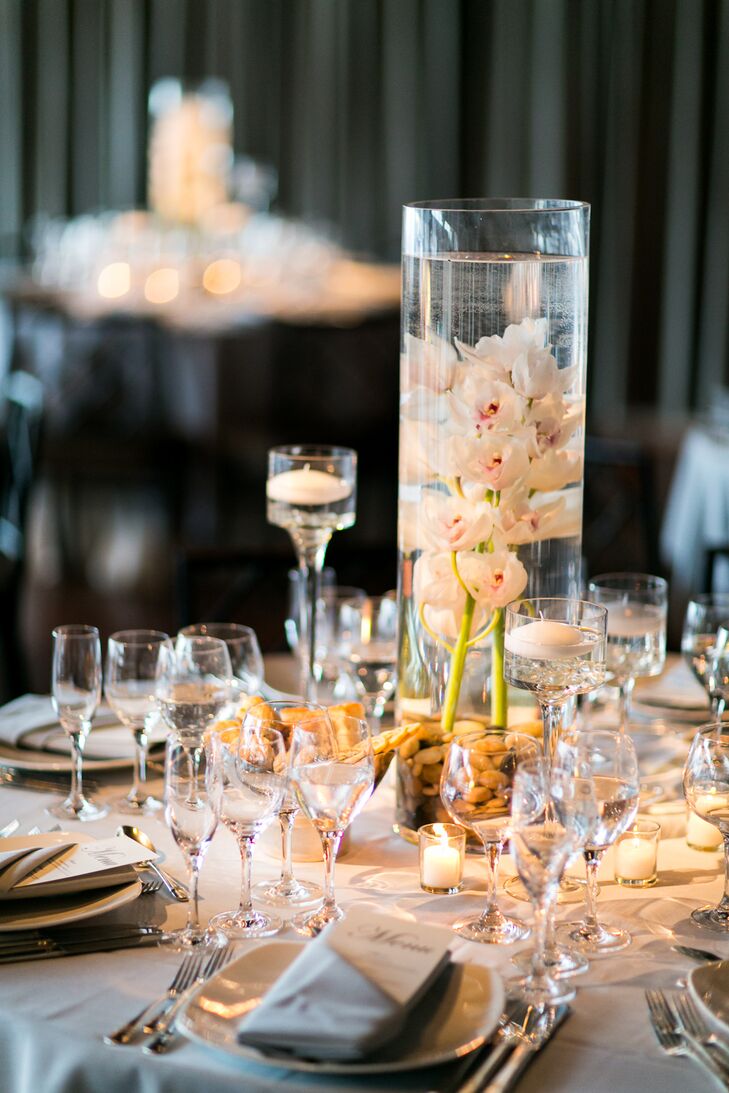White orchids were floated in cylinder vases alongside floating candles on some of the reception tables.