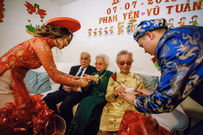 Couple serving tea to elders during Vietnamese wedding ceremony