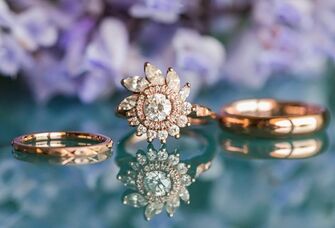 rose gold engagement ring with floral halo and wedding bands