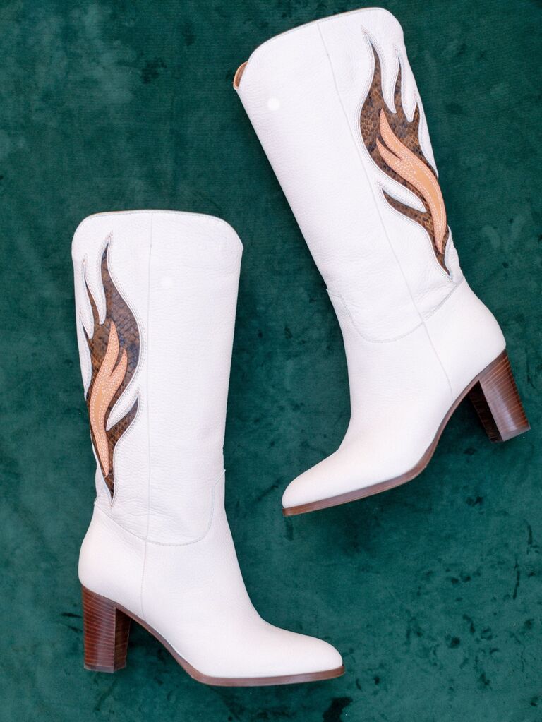 White cowboy boots with a stylish flame embellishment along each side. 