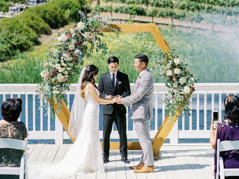 wedding officiant couple smiling holding hands outside