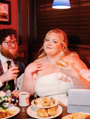 Bride With Striking Makeup and Cocktail With Groom at Diner Reception Table