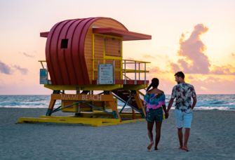 Couple walking on Miami Beach at sunset