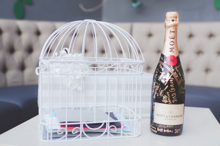 A table was set up with a closed bottle of Moet champagne for the guests to inscribe with their best wishes to the couple, as well as a birdcage for those who wished to insert a more lengthy letter for My-Lee and James.