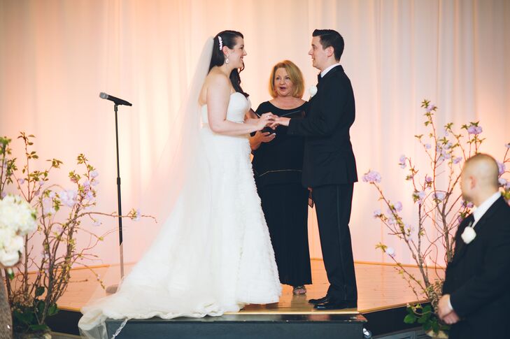 To make the Gershon Fox Ballroom Atrium’s their own, Pamela and Dan covered their ceremony in romantic decor. With the help of Amy Champagne Events, they covered the backdrop in blush draped fabric and white uplighting. Fleurescent heightened the atmosphere with cherry blossoms on either side of their stage.