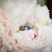 Wedding Rings Resting on White Peonies Bridal Bouquet