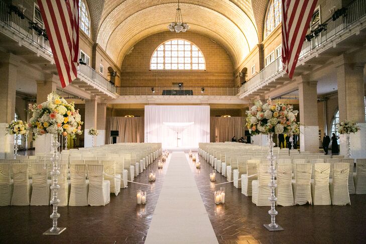 The day kicked off with a ceremony in the iconic Registry Room at Ellis Island in New York City. The high ceilings and stately arches set a grand, elegant tone for the evening, with soft candlelight and lush arrangements of hydrangeas and garden roses displayed atop tall, silvery stands only adding to the effect. “We walked down the aisle, which was lined with candles, just as the sun was setting and the pink and purple sky painted the windows like stained glass,” Lauren says. “The setting looked so magical, it was almost haunting.”
