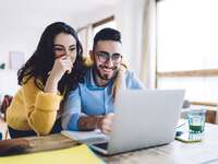 Couple using laptop at home