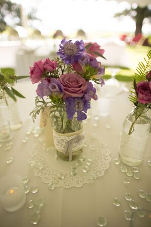 Purple Flowers in Glass Bottle Centerpiece