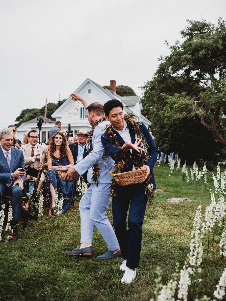 adult men tossing flower petals down the aisle