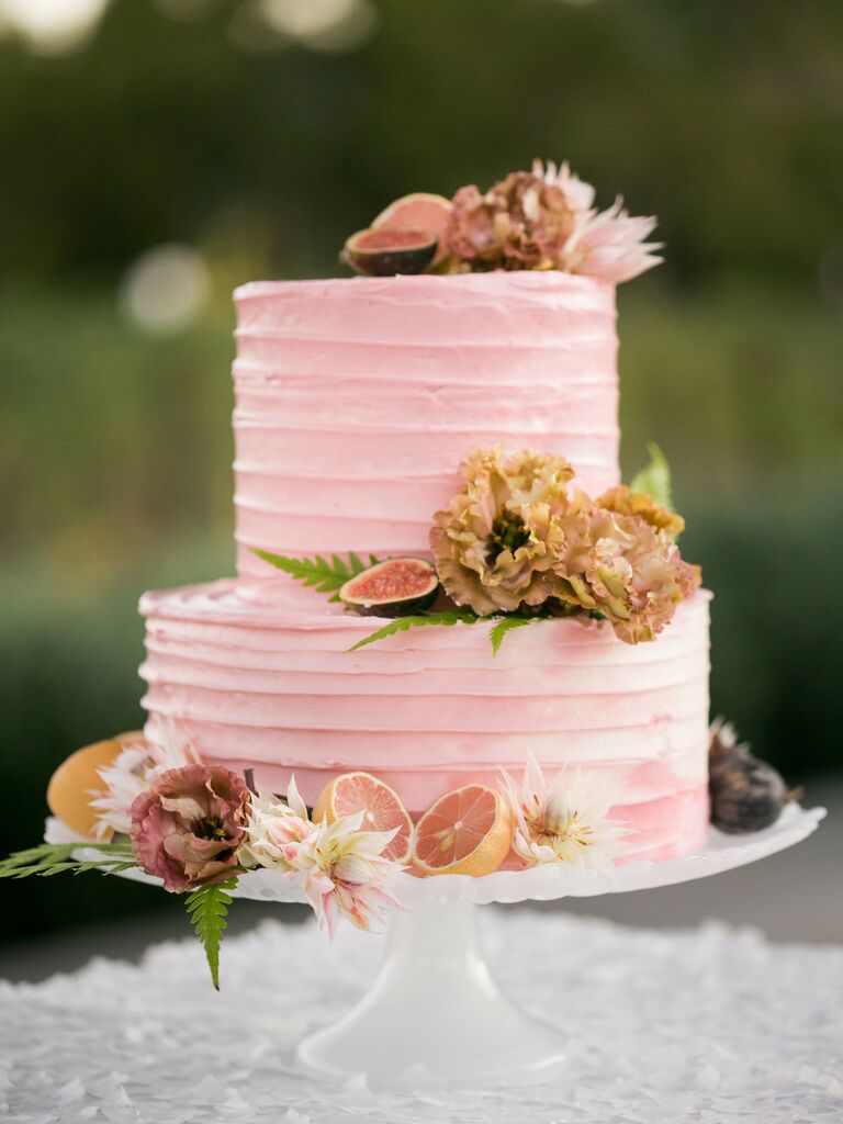two tier pink wedding cake with sliced grapefruits, figs and blush flowers