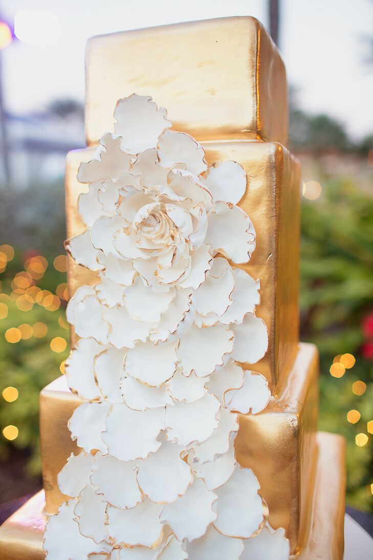 The couple treated their guests to a bold four-tier gold confection decorated with a large white composite flower.