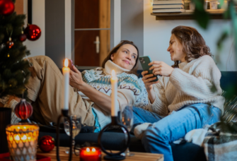 two girlfriends on couch at Christmas time