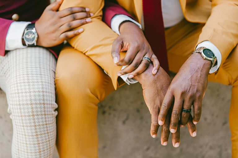 Close up of engagement rings on couple's hands