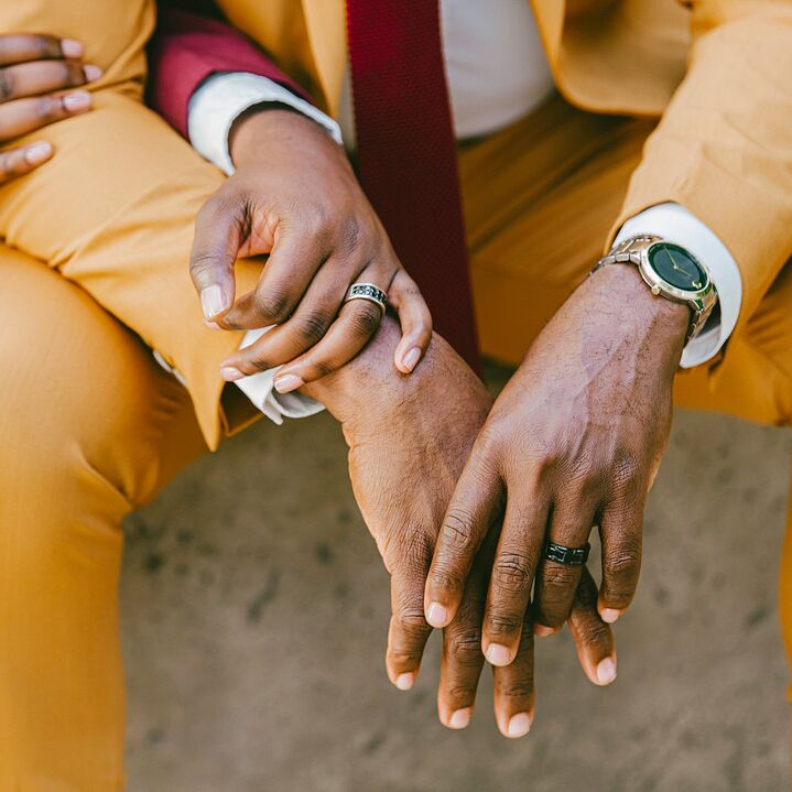 Close up of engagement rings on couple's hands