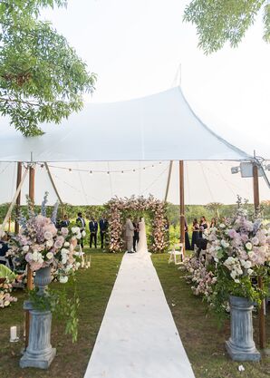 Tented Ceremony Space With White Aisle, Pastel Flower Arrangements in Vases, Colorful Chuppah