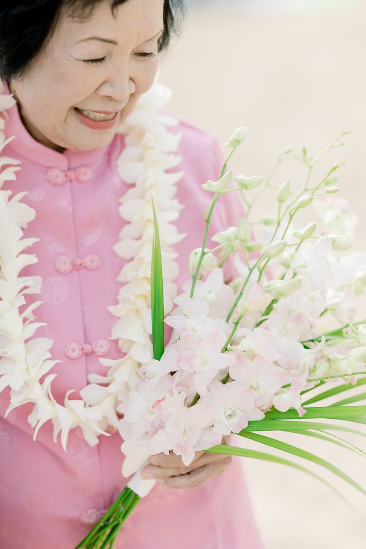A beautiful, textural bouquet with light blush orchids and greenery fronds for a beachy, casual wedding in Hawaii.