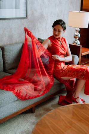 Bride Admiring Red Veil With Intricate Detailing in Red Qipao Dress, Red Shoes