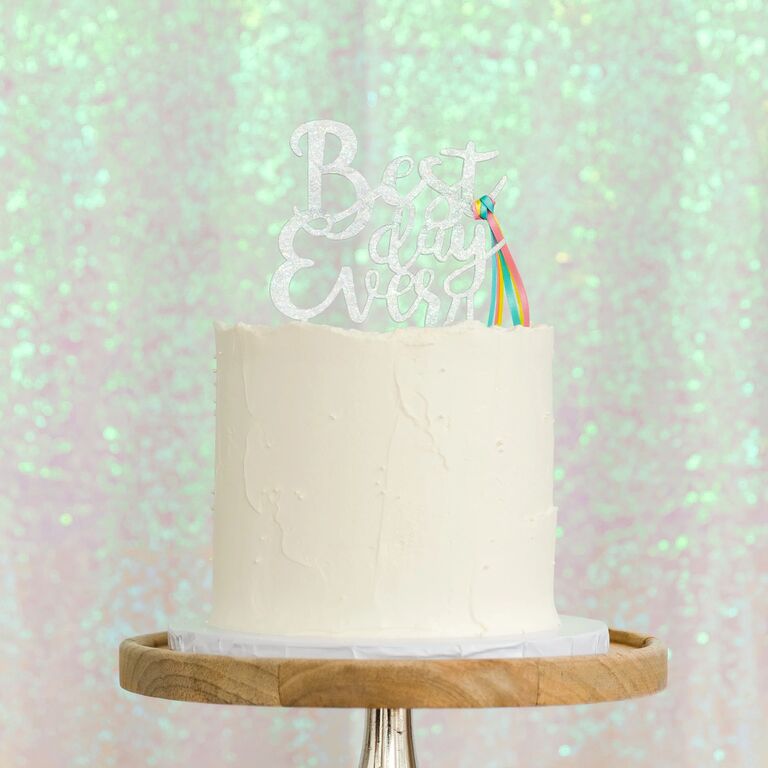 "Best Day Ever" cake topper with a rainbow ribbon.