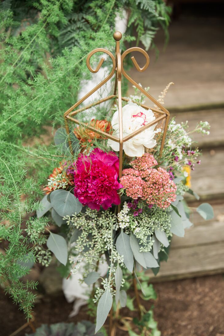 "My mom, extended family and friends put together over 50 amazing montages of flowers, plants and gold accent pieces throughout the space," Andi says of the floral arrangements.
