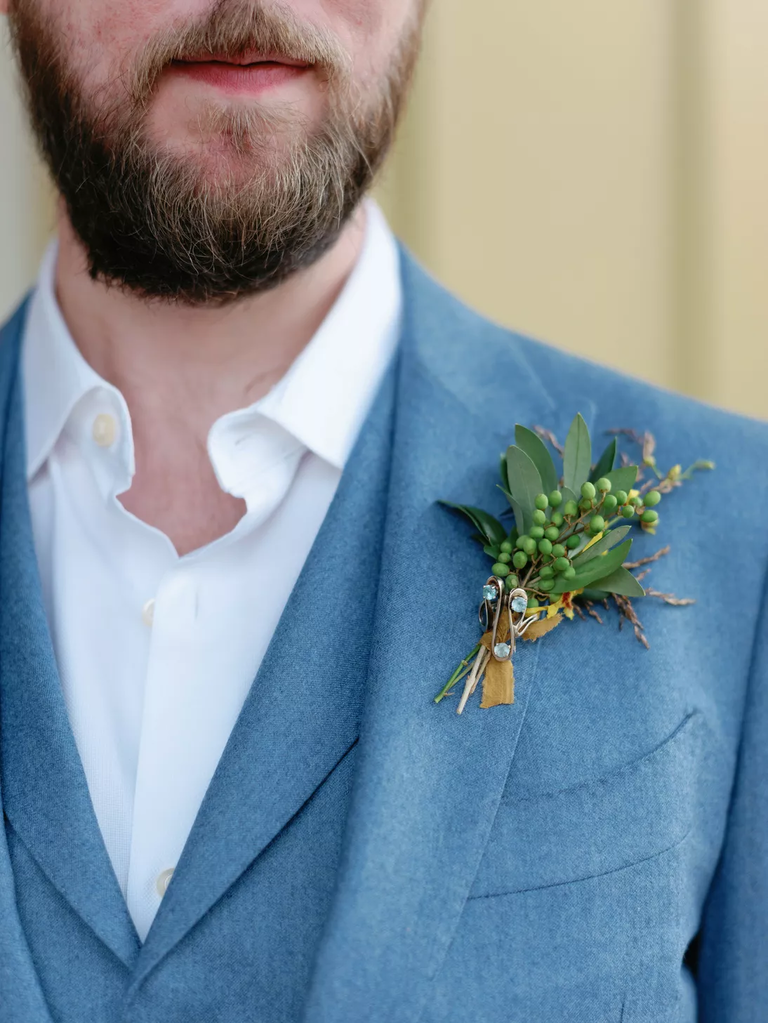 A groom shows off this delightful understated greenery boutonniere.