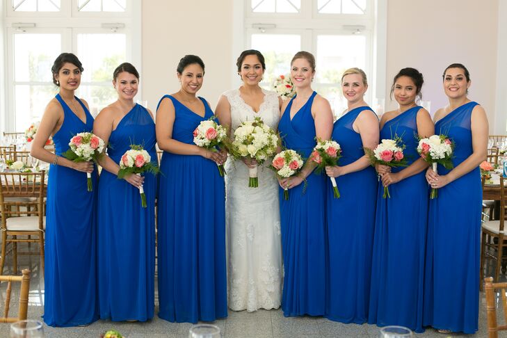 Natalie's bridesmaids wore cobalt blue floor-length dresses in one-shoulder or V-neck styles. Bouquets of ivory and coral with touches of greenery tied in the romantic beach theme.
