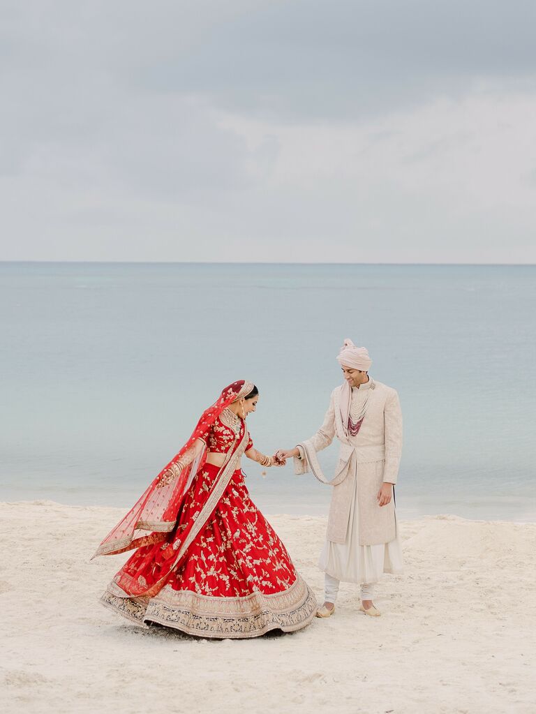 Bride and groom posing for wedding portraits on beach