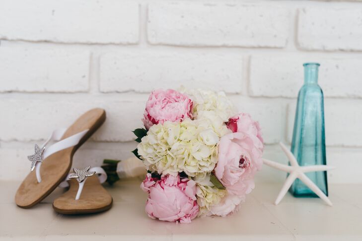 The bride carried a bouquet of white hydrangeas and pink peonies. Her dress was also paired with starfish accented flip-flops.