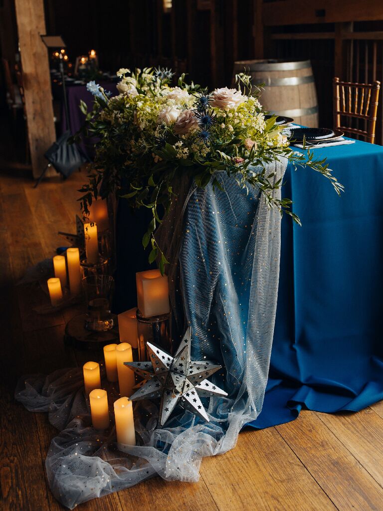 Celestial wedding decorations covering sweetheart table with table runner and candles at zodiac wedding