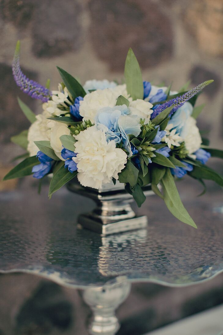 The couple paired white carnations with purple delphinium and blue hydrangeas to create a pop of color to the reception.