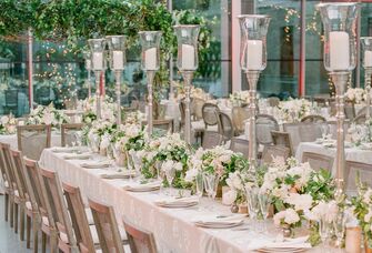 spring wedding tablescape with tall silver candlesticks and low centerpieces with white flowers