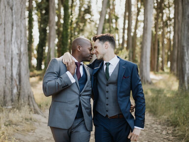 Two grooms share a romantic moment beneath the trees for their fall engagement photoshoot