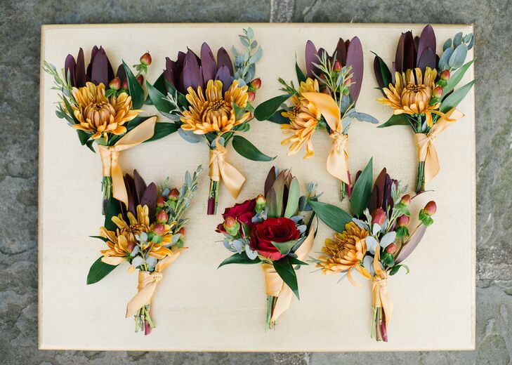 Drawing on the colors of the season, the boutonnieres were filled with mums, roses, hypericum berries and greenery in shades of deep burgundy, gold and red.