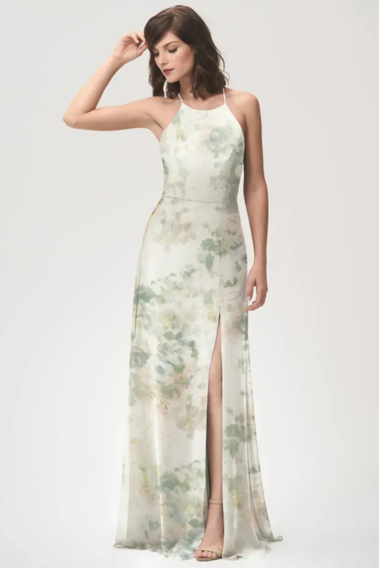 Model wears a floor length dress with a halter neckline and a gorgeous floral print. 