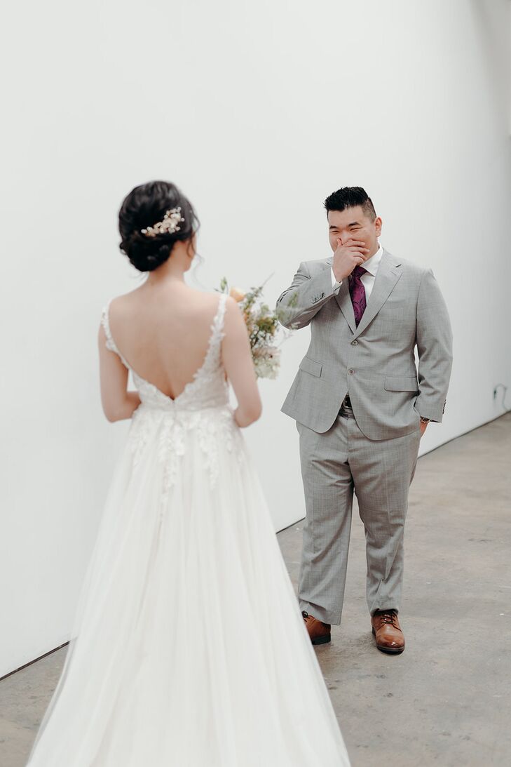 Groom in Gray Suit Seeing Bride in Tulle A-Line, Deep-V Back With Updo, First Look
