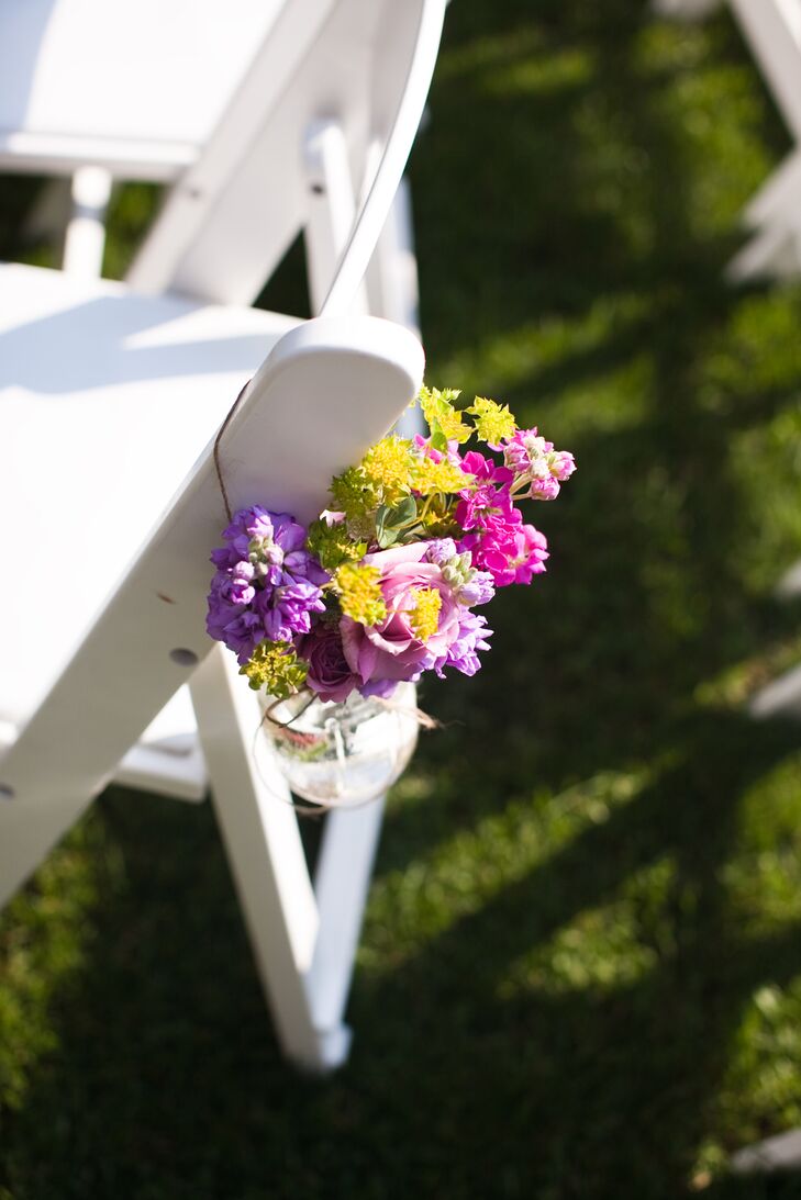 Purple, pink and yellow flower bouquets hung from ceremony chairs decorated the aisle with pops of color.