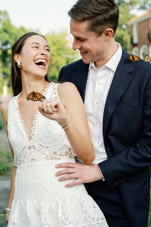 Bride Holding Monarch Butterfly and Laughing During Rehearsal Dinner