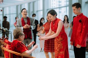 Bride Serving Her Older Relatives During Traditional Chinese Tea Ceremony, Red Attire