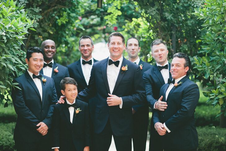 Aron and his groomsmen sported dark navy tuxedos and black bow ties for a modern spin on a classic look that complemented the bridesmaids' dresses.