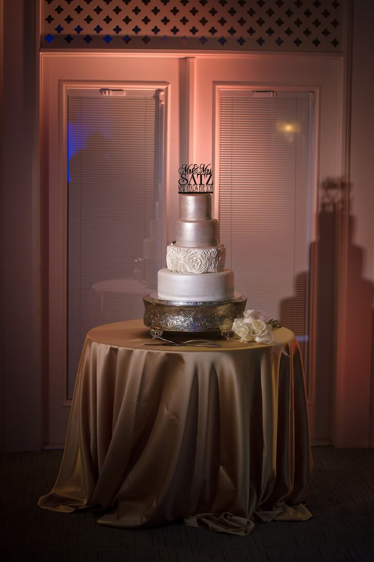 The team at Creative Cake Factory added an elegant yet dramatic touch to the couple's New Year's Eve celebration. Each layer of red velvet or almond white cake was covered in an eye-catching layer of silver or diamond white frosting. One tier was also covered with a fun rosette design that tied the look together. Irina and Richard then added a personal touch with their black topper.