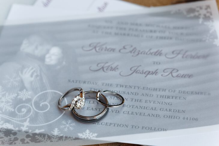 The engagement ring, wedding ring and band were arranged on top of ivory stationary designed with snowflakes and swirls for the winter occasion.