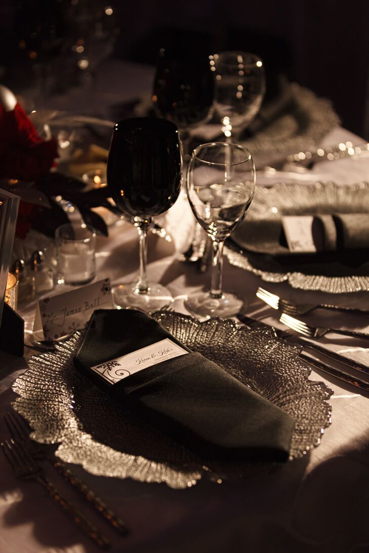 Black linens were folded with menu cards inside on the dining table and positioned on top of elegant silver dinnerware.