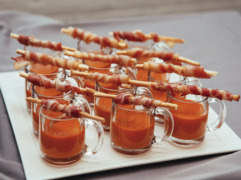 Tomato soup shooters with breadsticks and bacon as a winter wedding food idea. 