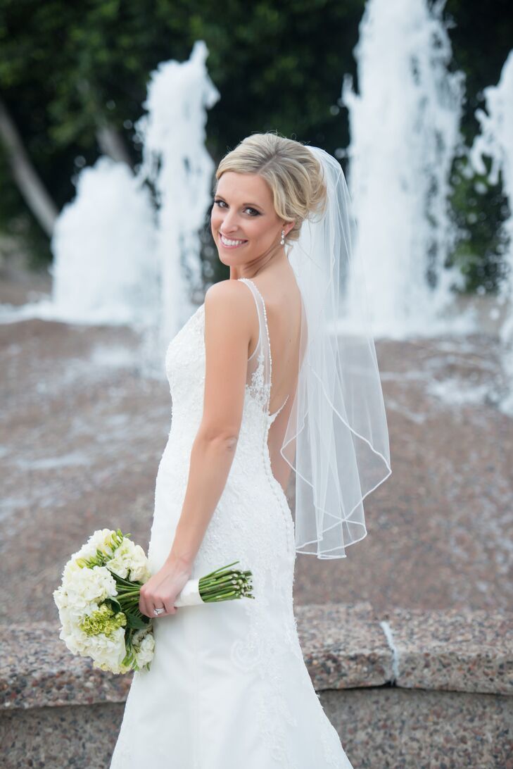 Brianna’s dress was absolutely stunning! She wore a sleeveless ivory trumpet-style wedding dress with lace appliques, an illusion neckline and a plunging back lined with buttons.