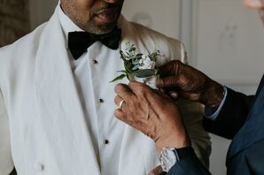 Father Helping Groom in White Tuxedo Jacket Put on White-and-Green Boutonniere