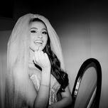 Black and white photo of bride applying lip gloss in veil